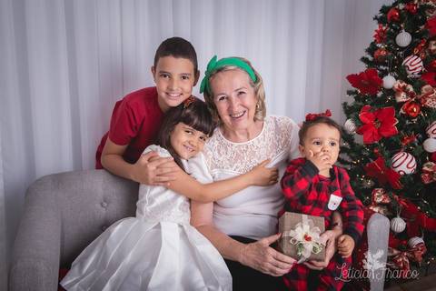 ensaio de natal infantil criança touca de papai noel 2019 brasilia df registrado pela fotógrafa letícia franco casa do papai noel cama arvore guirlanda sala irmãos com a vovó'