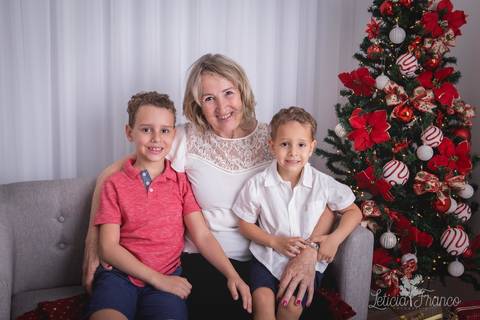 ensaio de natal infantil criança touca de papai noel 2019 brasilia df registrado pela fotógrafa letícia franco casa do papai noel cama arvore guirlanda sala irmãos vovó'
