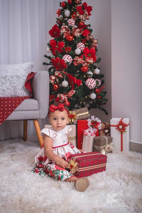 ensaio de natal bebê touca de papai noel 2019 brasilia df registrado pela fotógrafa letícia franco casa do papai noel sala arvore guirlanda roupa de papai noel luisa presentes'