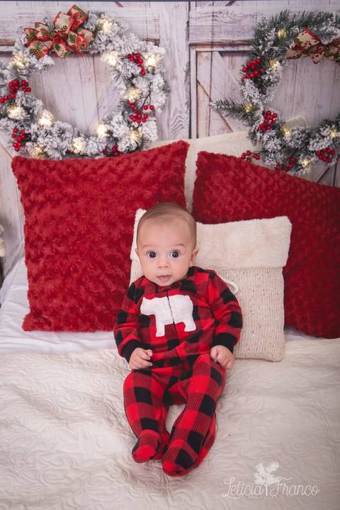 ensaio de natal bebê touca de papai noel 2019 brasilia df registrado pela fotógrafa letícia franco quarto do papai noel cama arvore guirlanda  théo sentado'