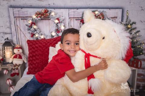 ensaio de natal bebê touca de papai noel 2019 brasilia df registrado pela fotógrafa letícia franco quarto do papai noel cama arvore guirlanda  julio abraçando o urso ursão'