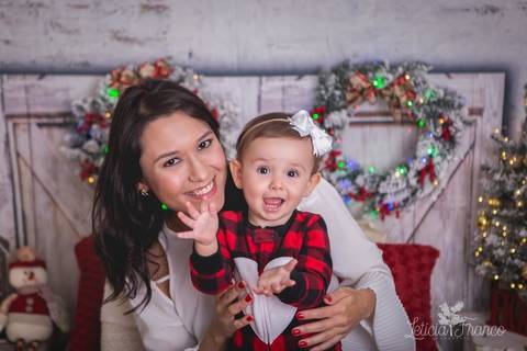 ensaio de natal bebê touca de papai noel 2019 brasilia df registrado pela fotógrafa letícia franco quarto do papai noel cama arvore guirlanda  bebe marina batendo palma com a mamãe aline'