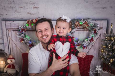 ensaio de natal bebê touca de papai noel 2019 brasilia df registrado pela fotógrafa letícia franco quarto do papai noel cama arvore guirlanda pai juan bebe marina com pijama'