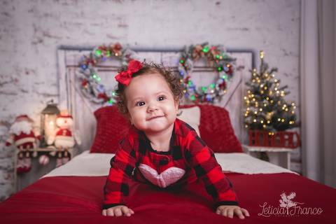 ensaio de natal bebê touca de papai noel 2019 brasilia df registrado pela fotógrafa letícia franco quarto do papai noel cama arvore guirlanda maitê de bruços pijama carters'