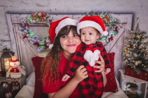 ensaio de natal bebê touca de papai noel 2019 brasilia df registrado pela fotógrafa letícia franco quarto do papai noel cama arvore guirlanda irmãs maitê e anne pijama cartes'