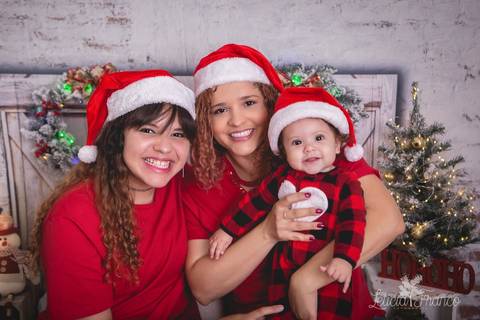 ensaio de natal bebê touca de papai noel 2019 brasilia df registrado pela fotógrafa letícia franco quarto do papai noel cama arvore guirlanda mãe e irmã família maitê pijama carters'