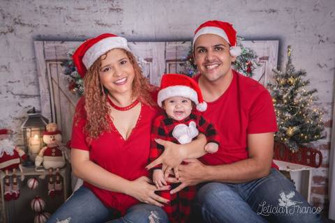 ensaio de natal bebê touca de papai noel 2019 brasilia df registrado pela fotógrafa letícia franco quarto do papai noel cama arvore guirlanda família pai thiago mãe alane pijama carters '