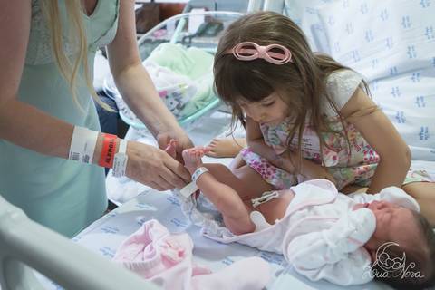 nascido maternidade santa helena parto fotografa fotografo fotógrafa brasília DF gestante sala de parto fotografia registrado pela fotografa Letícia Franco hospital primeiros cuidados trocando fralda com a irmã'
