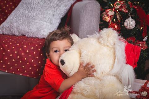 ensaio de natal bebê touca de papai noel 2019 brasilia df registrado pela fotógrafa letícia franco casa do papai noel sala arvore guirlanda roupa de papai noel abraçando ursão'