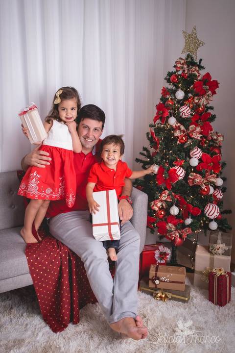 ensaio de natal bebê touca de papai noel 2019 brasilia df registrado pela fotógrafa letícia franco casa do papai noel sala arvore guirlanda roupa de papai noel papai alfredo com giovanna e vitor com presentes'