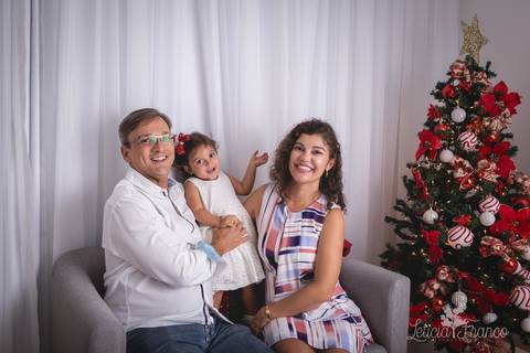 ensaio de natal bebê touca de papai noel 2019 brasilia df registrado pela fotógrafa letícia franco casa do papai noel sala arvore guirlanda roupa de papai noel maria teresa com pais papai renato e mamãe maristela'