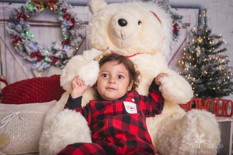 ensaio de natal bebê touca de papai noel 2019 brasilia df registrado pela fotógrafa letícia franco quarto do papai noel cama arvore guirlanda pijama carter's carters maria teresa abraçando ursão urso'