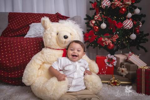 ensaio de natal bebê touca de papai noel 2019 brasilia df registrado pela fotógrafa letícia franco casa do papai noel sala arvore guirlanda roupa de papai noel estêvão com urso'