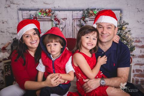 ensaio de natal bebê touca de papai noel 2019 brasilia df registrado pela fotógrafa letícia franco quarto do papai noel cama arvore guirlanda pijama carter's carters família se abraçando'
