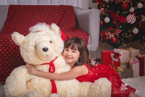 ensaio de natal bebê touca de papai noel 2019 brasilia df registrado pela fotógrafa letícia franco casa do papai noel sala arvore guirlanda roupa de papai noel maria helena abraçando urso ursão'