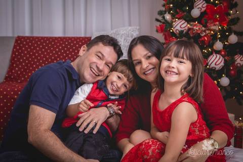 ensaio de natal bebê touca de papai noel 2019 brasilia df registrado pela fotógrafa letícia franco casa do papai noel sala arvore guirlanda roupa de papai noel família sorrindo e se abraçando filhos irmãos pais irmã irmão '