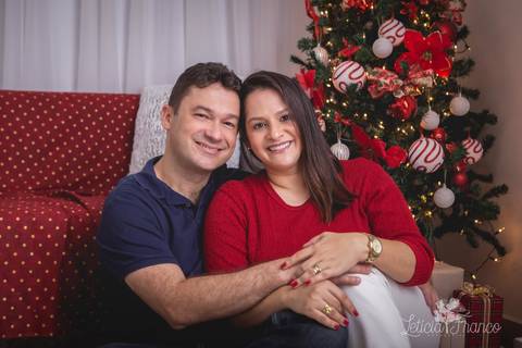 ensaio de natal bebê touca de papai noel 2019 brasilia df registrado pela fotógrafa letícia franco casa do papai noel sala arvore guirlanda roupa de papai noel casal se abraçando amor '