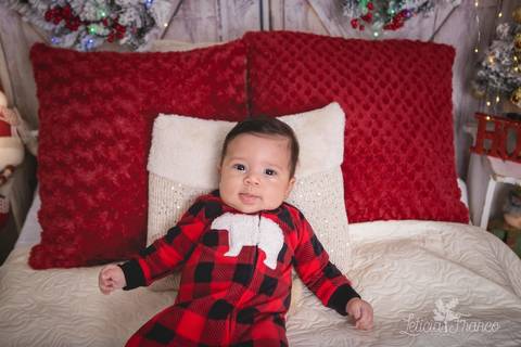 ensaio de natal bebê touca de papai noel 2019 brasilia df registrado pela fotógrafa letícia franco quarto do papai noel cama arvore guirlanda pijama carter's carters bebe de 3 meses romero encostado meio sentado'