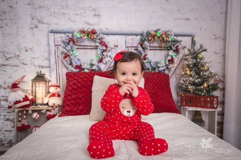 ensaio de natal bebê touca de papai noel 2019 brasilia df registrado pela fotógrafa letícia franco quarto do papai noel cama arvore guirlanda pijama carter's carters antonella sentada com mão na boca'
