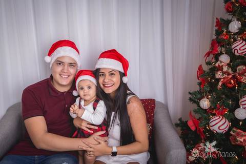 ensaio de natal bebê touca de papai noel 2019 brasilia df registrado pela fotógrafa letícia franco casa do papai noel sala arvore guirlanda roupa de papai noel família sentada no sofá papai mamãe filha wdson nayara antonella roupinha da carters carter's s'