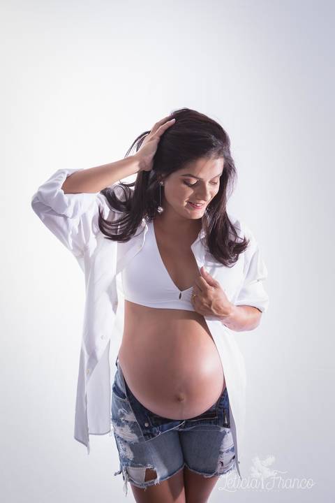 ensaio gestante mamãe recém nascido newborn fotografa fotógrafa brasília df distrito federal baby bebe reborn book melhor leticia franco letícia estúdio 33 semanas gestante com a mão no cabelo e na camiseta'