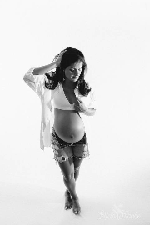 ensaio gestante mamãe recém nascido newborn fotografa fotógrafa brasília df distrito federal baby bebe reborn book melhor leticia franco letícia estúdio foto preto e branco mão no cabelo e segurando camiseta pernas cruzadas'