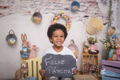 brasilia leticia franco fotografia df lago sul jardim botanico candy colors coelhos orelha de coelho body de renda de manga cumprida apolo sentado no caixote segurando placa de feliz páscoa e sorrindo'