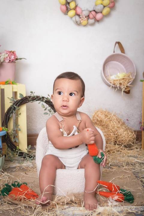 ensaio de páscoa em brasilia leticia franco fotografia df lago sul jardim botanico candy colors coelhos orelha de coelho gabriel segurando a cenoura olhando pra cima'