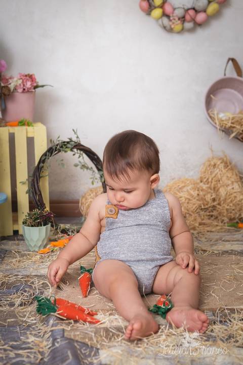 ensaio de páscoa em brasilia leticia franco fotografia df lago sul jardim botanico candy colors coelhos orelha de coelho fernando sorrindo com macacão cinza com cenoura olhando pra ela'