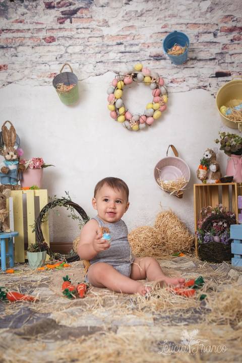 ensaio de páscoa em brasilia leticia franco fotografia df lago sul jardim botanico candy colors coelhos orelha de coelho fernando sorrindo com macacão cinza segurando ovo e sorrindo'