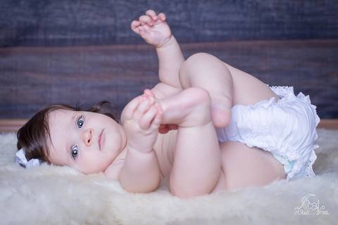 baby deitado segurando o pé bebe 6 7 meses'