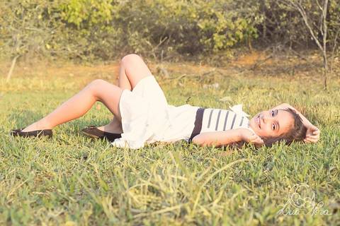 criança deitada no chão da fazenda'