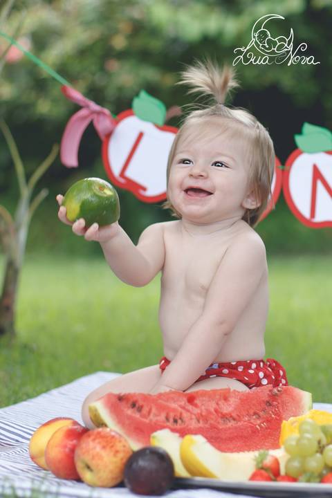 bebe sorrindo segurando fruta laranja brasilia smash'