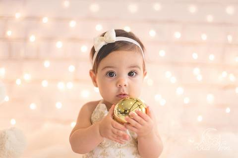 bebe segurando bola de natal dourada com 6 meses no ensaio de natal acompanhamento brasília brasilia'