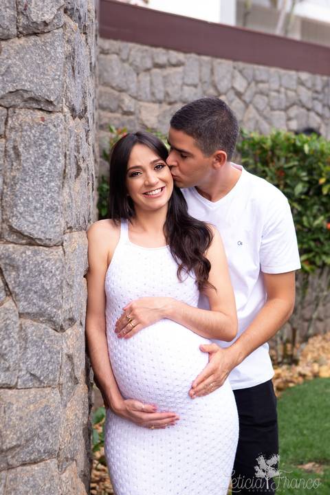ensaio gestante mamãe fotografa fotógrafa brasília df distrito federal baby bebe reborn book melhor leticia franco letícia estúdio 37 semanas gestante com papai beijando a bochecha roupas brancas na parede de pedra'