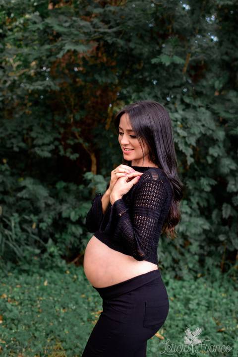 ensaio gestante mamãe fotografa fotógrafa brasília df distrito federal baby bebe reborn book melhor leticia franco letícia estúdio 37 semanas gestante com as mãos no ombro top preto fundo verde escuro folhas plantas'