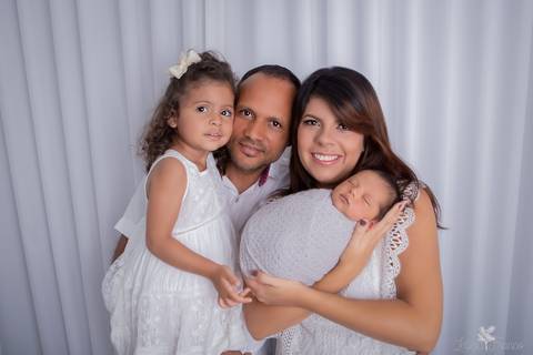 bebê recém nascido newborn brasilia fotografa fotografo fotógrafa brasília df distrito federal baby bebe reborn book melhor leticia franco menino com família papai mamãe e irmã enrroladinho no tecido wrap cinza fundo e roupas brancas'