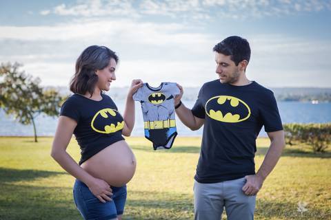 ensaio gestante mamãe fotografa fotógrafa brasília df distrito federal baby bebe reborn book melhor leticia franco letícia gestante e papai com roupa do batman e segurando a roupinha de bebe do batman parque perto do lago paranoá'