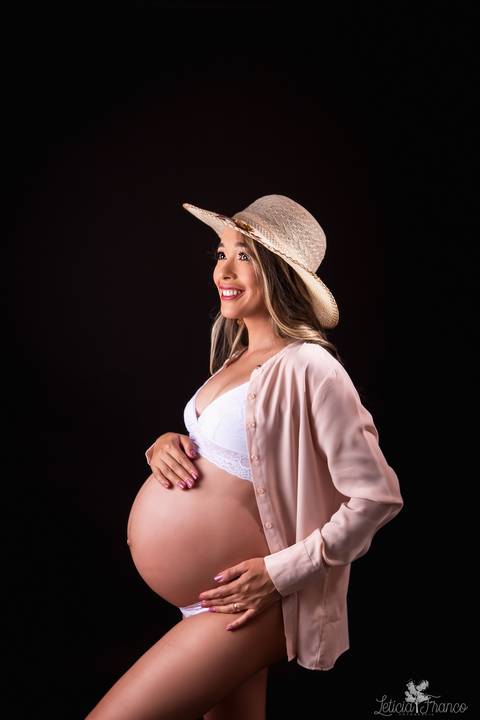 ensaio gestante mamãe fotografa fotógrafa brasília df distrito federal baby bebe reborn book melhor leticia franco letícia estúdio  gestante com a mão no cabelo e na barriga ligerie branca fundo preto sensual hobe casaco bege chapéu mão na barriga'