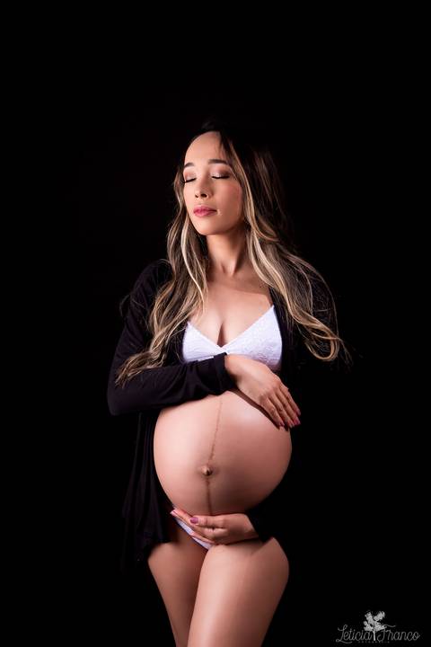 ensaio gestante mamãe fotografa fotógrafa brasília df distrito federal baby bebe reborn book melhor leticia franco letícia estúdio  gestante com a mão no cabelo e na barriga ligerie branca fundo preto sensual hobe casaco preto mão na barriga'