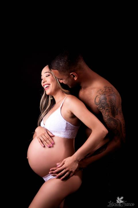 ensaio gestante mamãe fotografa fotógrafa brasília df distrito federal baby bebe reborn book melhor leticia franco letícia estúdio  gestante com a mão no cabelo e na barriga ligerie branca fundo preto sensual com papai  cheirando o pescoço'