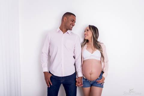 ensaio gestante mamãe fotografa fotógrafa brasília df distrito federal baby bebe reborn book melhor leticia franco letícia estúdio  gestante com a mão no cabelo e na barriga fundo branco com papai de mãos dadas sorrindo lingerie branca'