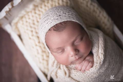 bebê recém nascido newborn brasilia fotografa fotografo fotógrafa brasília df distrito federal baby bebe reborn book melhor leticia franco menino enrroladinho no tecido branco com fundo azul bercinho com touca'