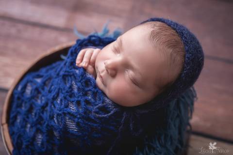 bebê recém nascido newborn brasilia fotografa fotografo fotógrafa brasília df distrito federal baby bebe reborn book melhor leticia franco menino enrroladinho no tecido branco com fundo azul com touca'
