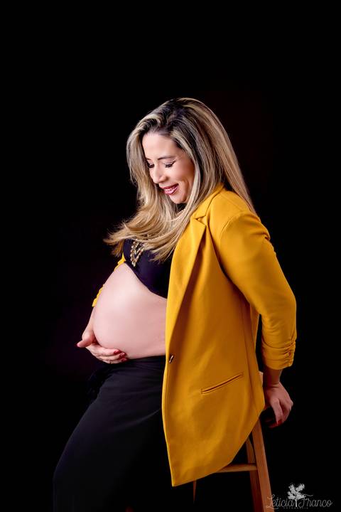 ensaio gestante mamãe fotografa fotógrafa brasília df distrito federal baby bebe reborn book melhor leticia franco letícia estúdio  gestante com roupa preta e mão na barriga sentada no banco com blazer mostarda'
