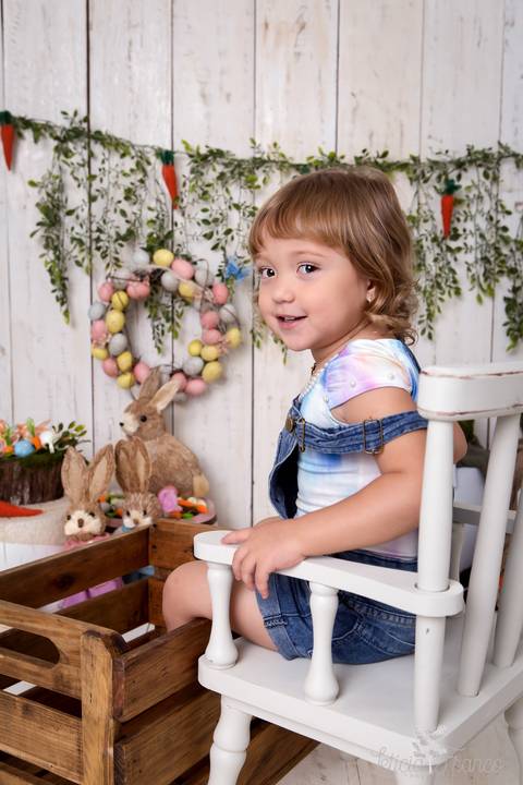 ensaio de páscoa em brasilia leticia franco fotografia df lago sul jardim botanico candy colors coelhos orelha de coelho baby book primeiro ano milestones maya sentada na cadeira com os pés dentro do caixote'