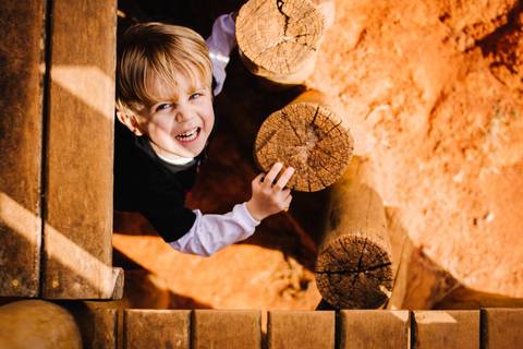 criança brincando de esconde esconde no parque'