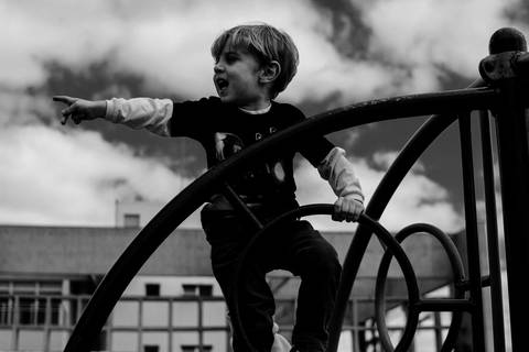 criança brincando no parquinho foto preto e branco'