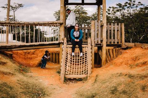 criança e pais brincando no playground de madeira no parque villa lobos'