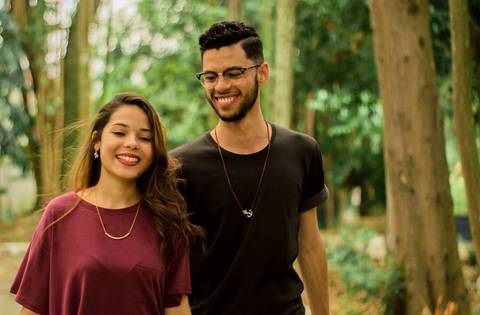 noivos correm felizes e sorridentes'